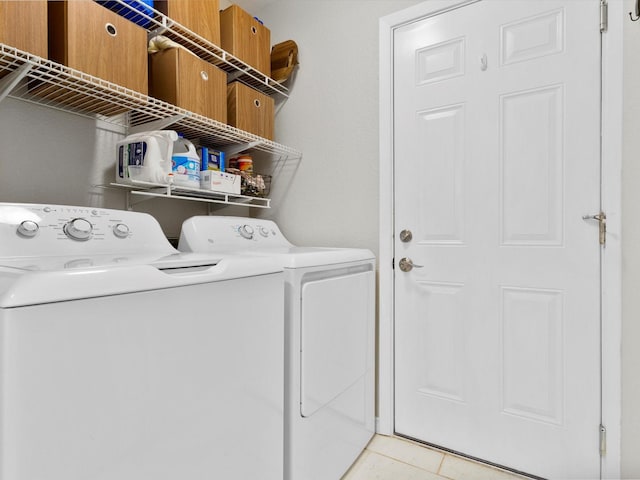 laundry area with light tile patterned floors and washing machine and clothes dryer