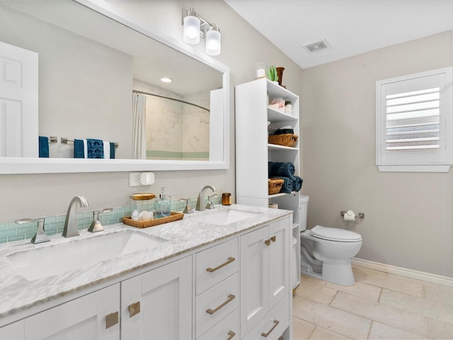 bathroom with tile patterned floors, vanity, toilet, and walk in shower