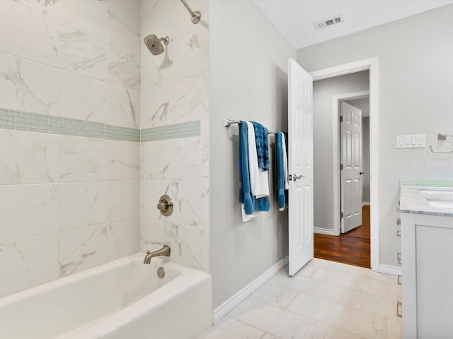 bathroom featuring vanity, hardwood / wood-style flooring, and tiled shower / bath