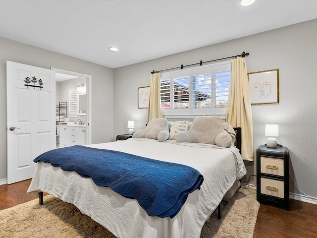 bedroom featuring sink, dark hardwood / wood-style floors, and connected bathroom