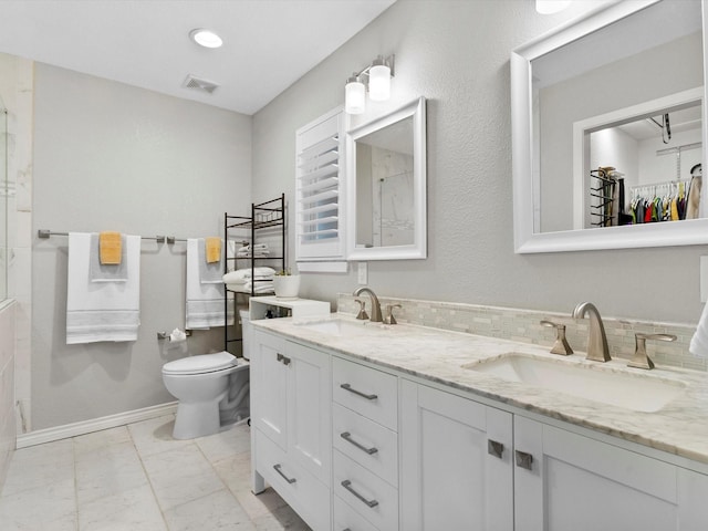 bathroom with vanity, tasteful backsplash, and toilet