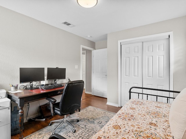 bedroom with dark hardwood / wood-style flooring and a closet