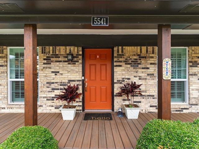 view of exterior entry featuring covered porch