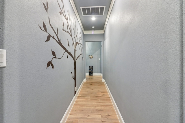 hall with crown molding and light hardwood / wood-style flooring