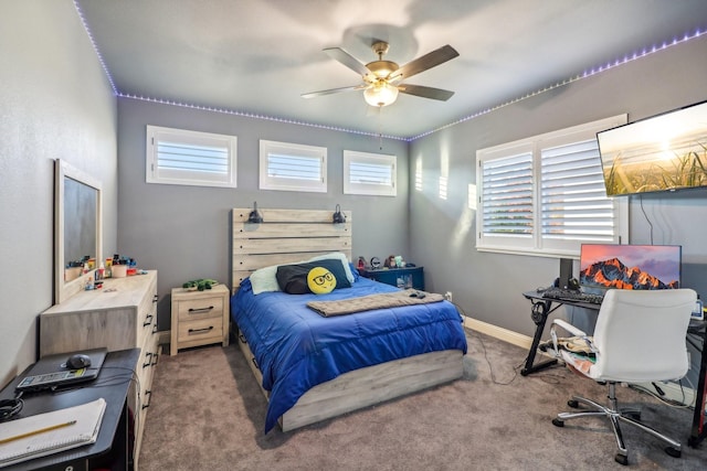 carpeted bedroom with ceiling fan and baseboards