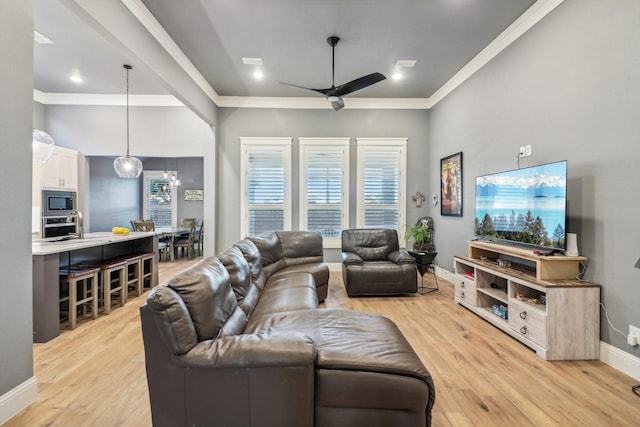 living room featuring ornamental molding, plenty of natural light, ceiling fan, and light hardwood / wood-style flooring