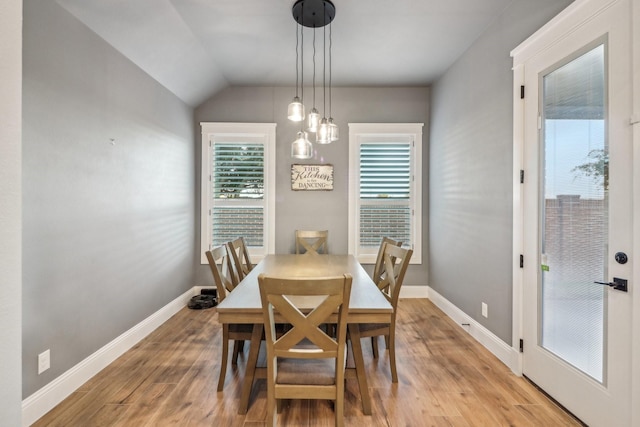 dining area featuring light hardwood / wood-style flooring and vaulted ceiling