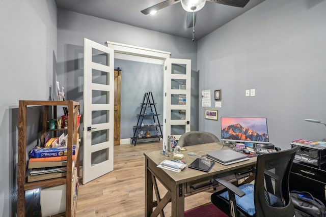 home office with light hardwood / wood-style flooring and ceiling fan