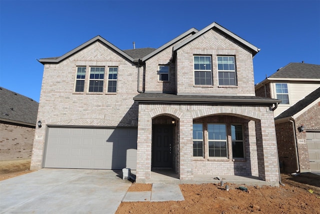 view of front of home with a garage, brick siding, and driveway