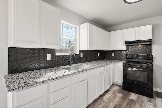 kitchen with sink, black electric range, hardwood / wood-style flooring, tasteful backsplash, and white cabinetry