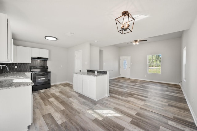 kitchen featuring sink, white cabinetry, hanging light fixtures, black / electric stove, and backsplash