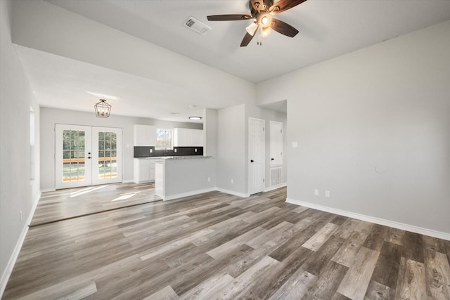 unfurnished living room with french doors, ceiling fan, and wood-type flooring