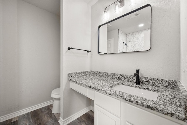 bathroom featuring hardwood / wood-style flooring, vanity, toilet, and walk in shower