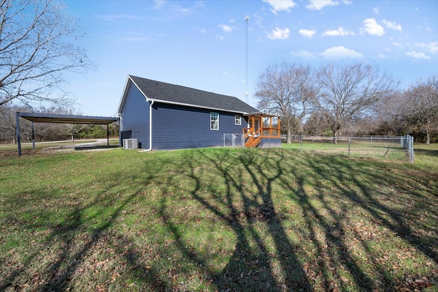 view of yard with a carport, central air condition unit, and a deck