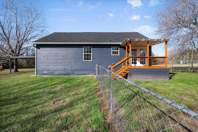 back of property featuring a deck and a lawn