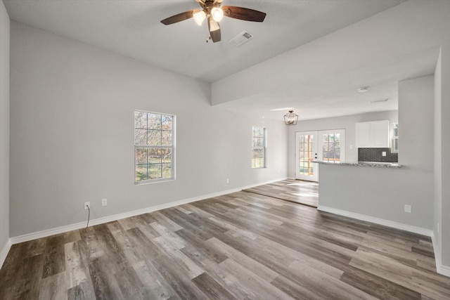 unfurnished living room featuring hardwood / wood-style flooring, ceiling fan, lofted ceiling, and french doors