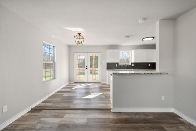 kitchen with french doors, backsplash, dark hardwood / wood-style floors, and white cabinetry