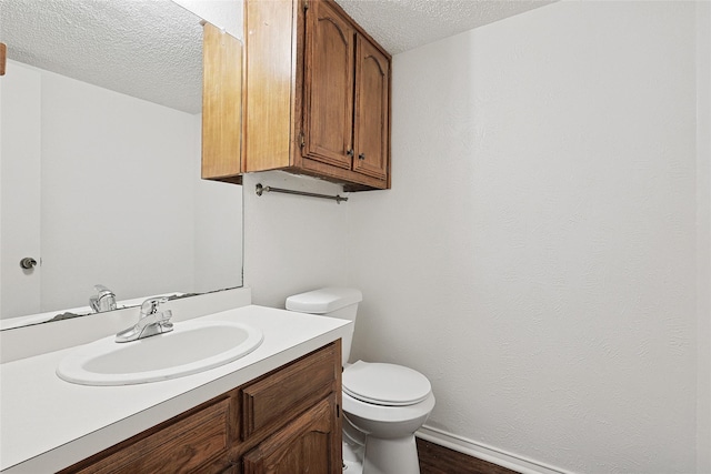 bathroom with vanity, wood-type flooring, a textured ceiling, and toilet