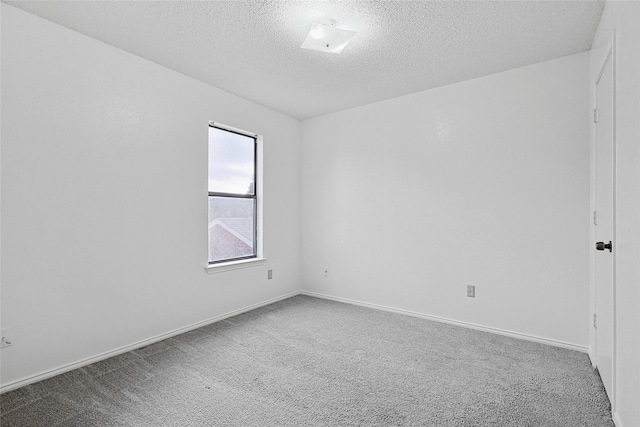 carpeted spare room with a textured ceiling