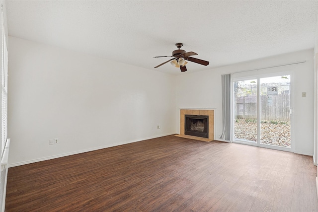 unfurnished living room featuring ceiling fan, a fireplace, wood-type flooring, and a textured ceiling