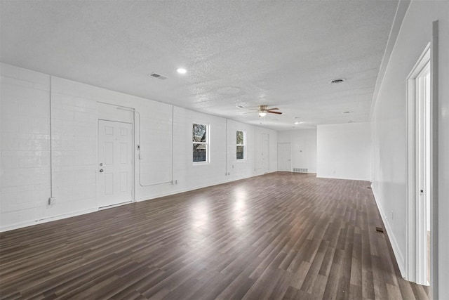 unfurnished living room featuring a textured ceiling, ceiling fan, and dark wood-type flooring