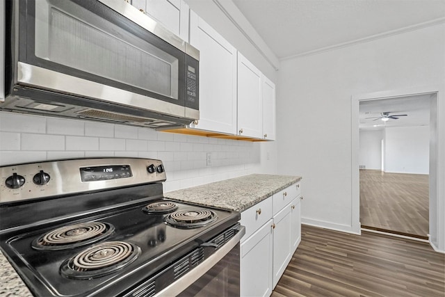 kitchen with tasteful backsplash, light stone counters, stainless steel appliances, dark wood-type flooring, and white cabinetry