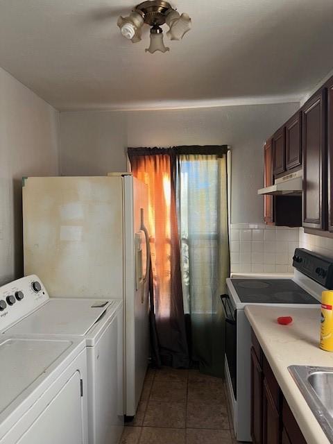 interior space with independent washer and dryer, light tile patterned floors, and sink