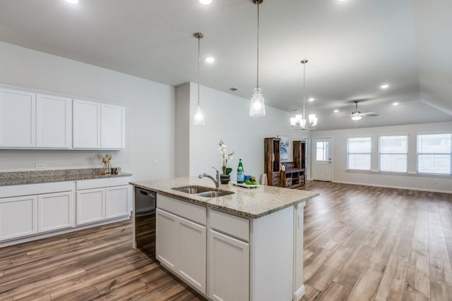 kitchen with hardwood / wood-style floors, white cabinets, ceiling fan with notable chandelier, a center island with sink, and sink