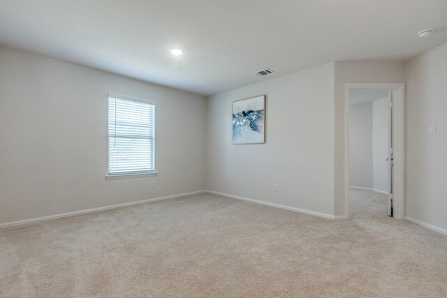 unfurnished room featuring light carpet