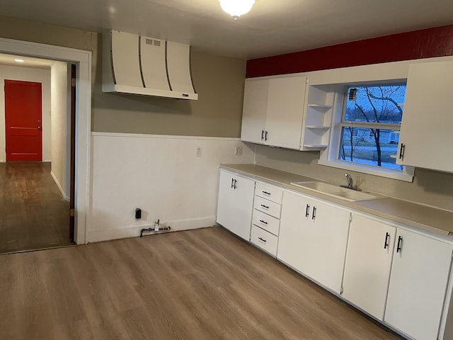 kitchen featuring light hardwood / wood-style flooring, white cabinetry, and sink