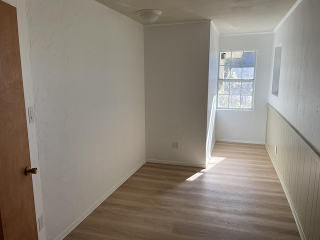 empty room with light wood-type flooring and ornamental molding