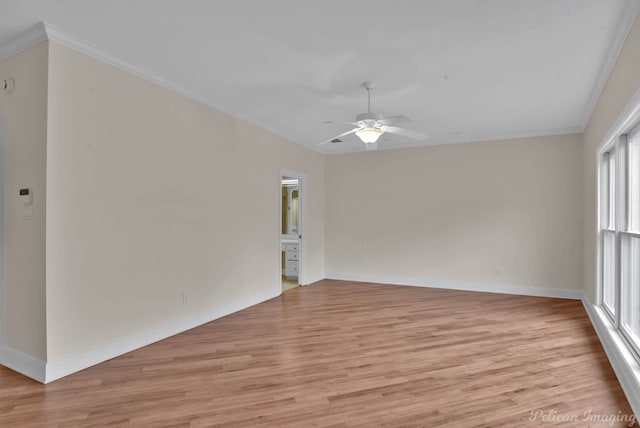 spare room with a ceiling fan, baseboards, crown molding, and light wood finished floors