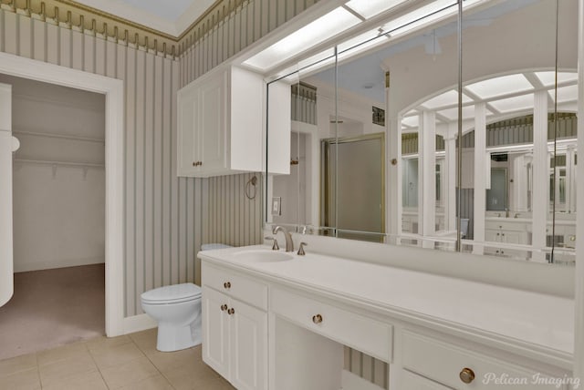 full bathroom with toilet, vanity, tile patterned floors, a stall shower, and wallpapered walls