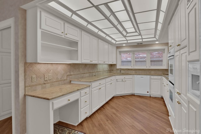 kitchen featuring sink, light stone counters, light hardwood / wood-style flooring, white appliances, and white cabinets