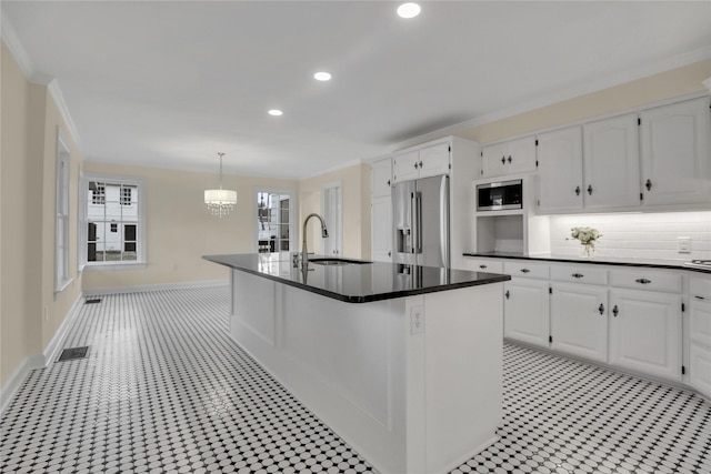 kitchen featuring white cabinets, dark countertops, stainless steel appliances, and a sink