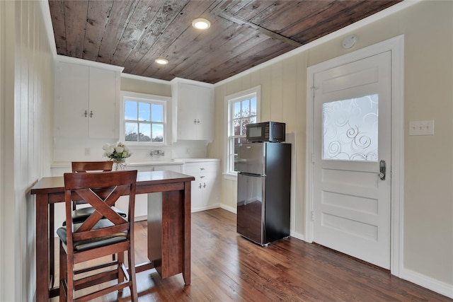 1102 Howell St, Mckinney, TX 75069 - kitchen featuring freestanding refrigerator, wood ceiling, black microwave, white cabinetry, and dark wood-type flooring