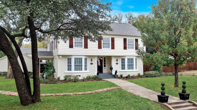 colonial inspired home featuring a front lawn