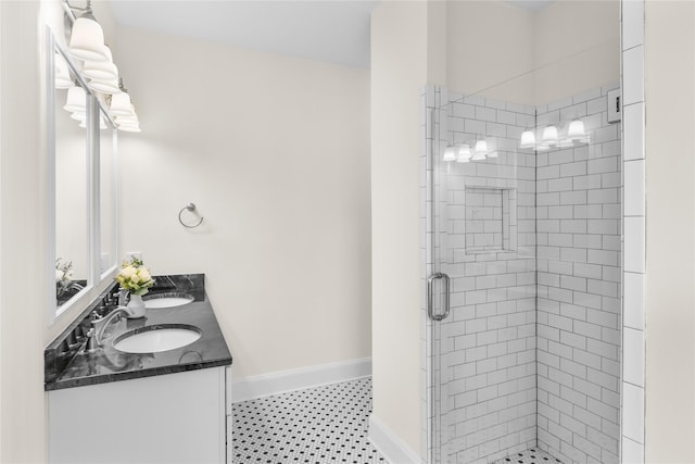 bathroom with tile patterned flooring, a sink, baseboards, double vanity, and a stall shower