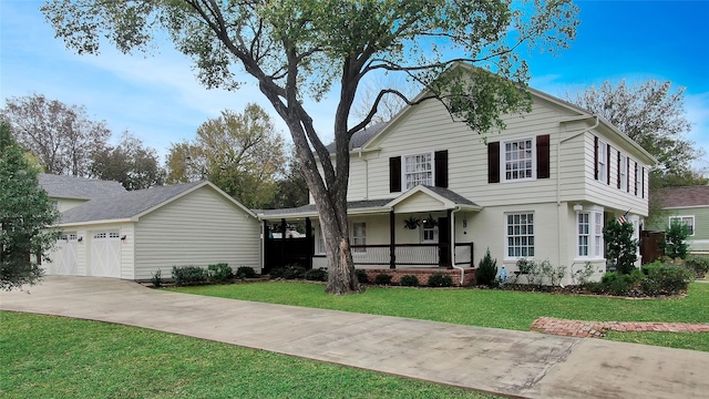 view of front of house featuring a porch, concrete driveway, a front lawn, and a garage