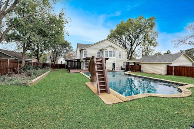 view of pool with a fenced backyard, a wooden deck, and a lawn