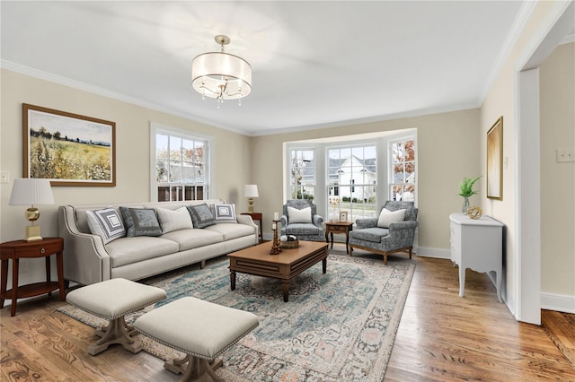 living area with crown molding, plenty of natural light, baseboards, and wood finished floors