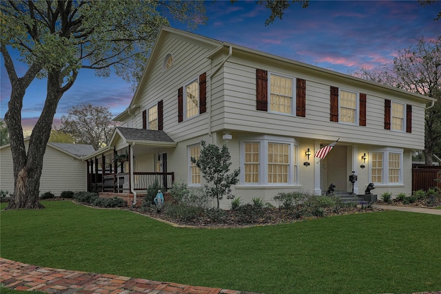 colonial house featuring a front lawn and brick siding