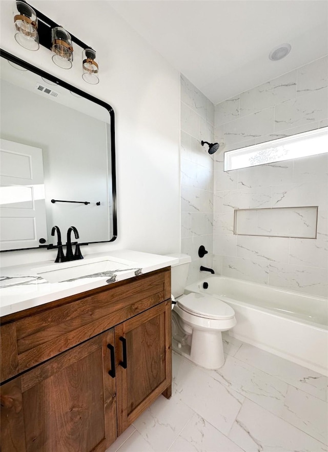 full bathroom featuring toilet, vanity, and tiled shower / bath