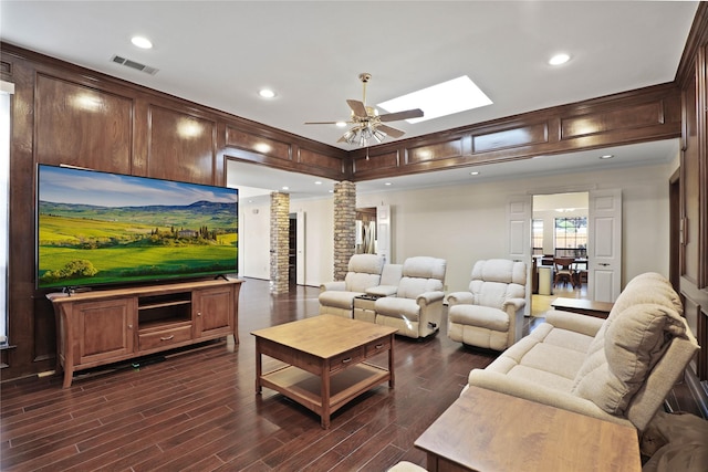 living room with ceiling fan, ornate columns, and a skylight