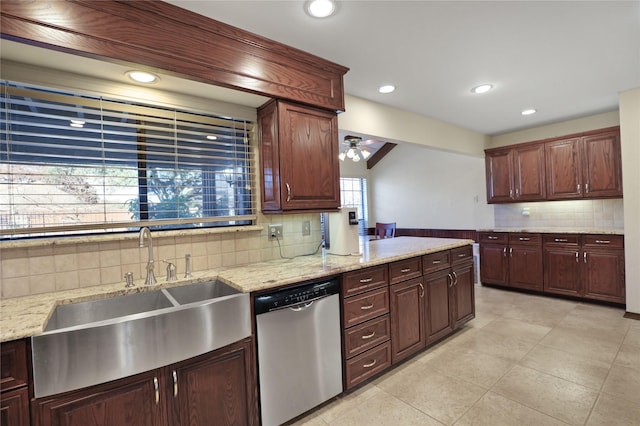 kitchen with stainless steel dishwasher, backsplash, light stone counters, and sink