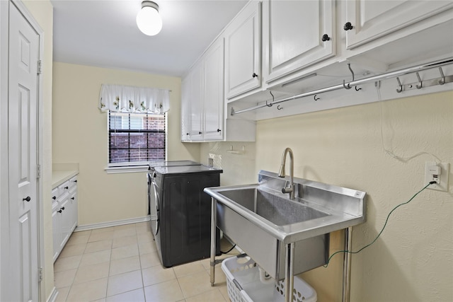 laundry room with washer and dryer, sink, light tile patterned flooring, and cabinets