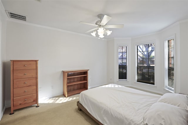 carpeted bedroom featuring ceiling fan and crown molding