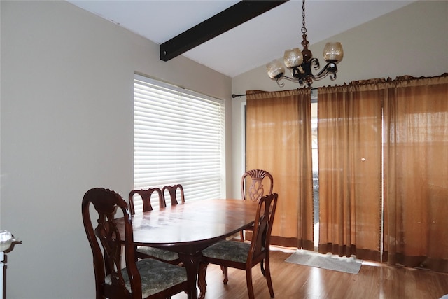 dining space featuring vaulted ceiling with beams, hardwood / wood-style flooring, and an inviting chandelier