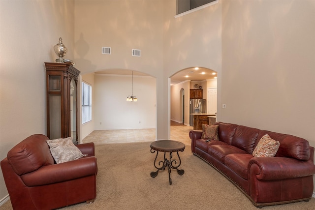 carpeted living room featuring a high ceiling