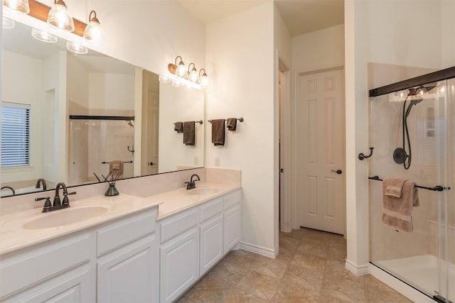 bathroom with a stall shower, double vanity, and baseboards